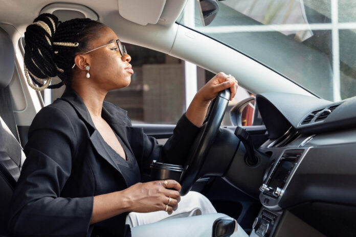 side-view-woman-driving-car-while-holding-cup-coffee