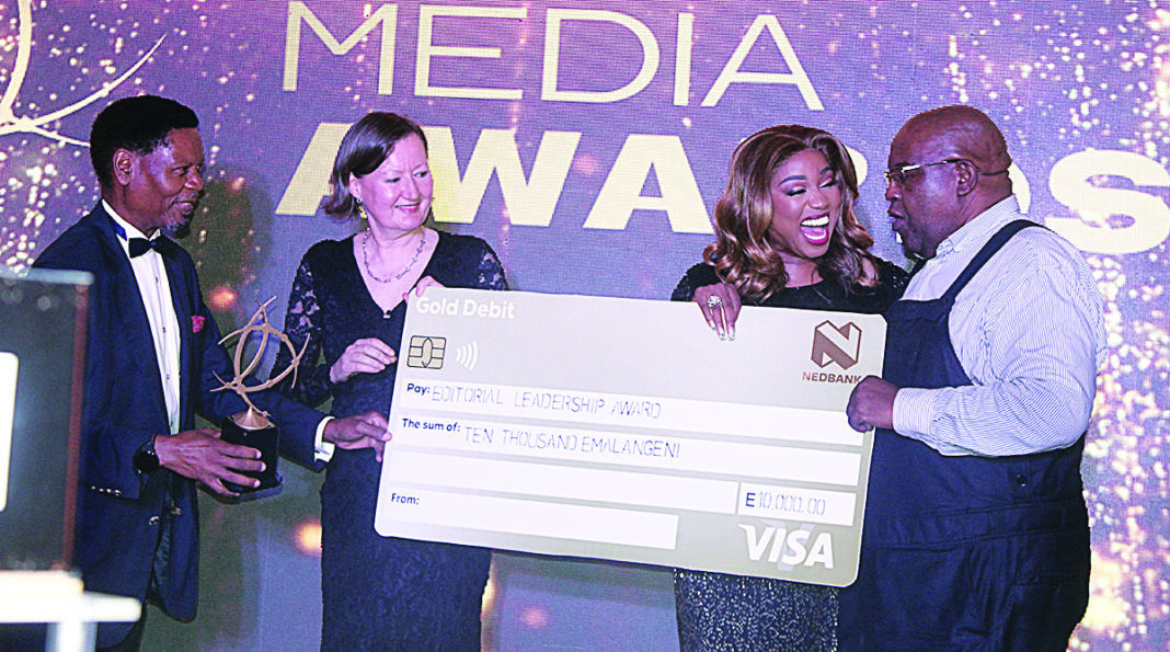 The Nation Magazine Editor Bheki Makhubu accepts his award for Editorial Leadership from Minister of ICT Savannah Maziya during the Media Awards held at the Royal Villas.