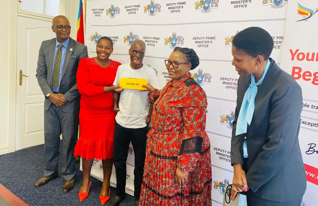 Deputy Prime Minister Thulisile Dladla handing over the tour ticket to Matse as Bahlelile Tsabedze, Makhosi Simelane and Eswatini Air Communications Manager Batsabile Nkambule looked on.