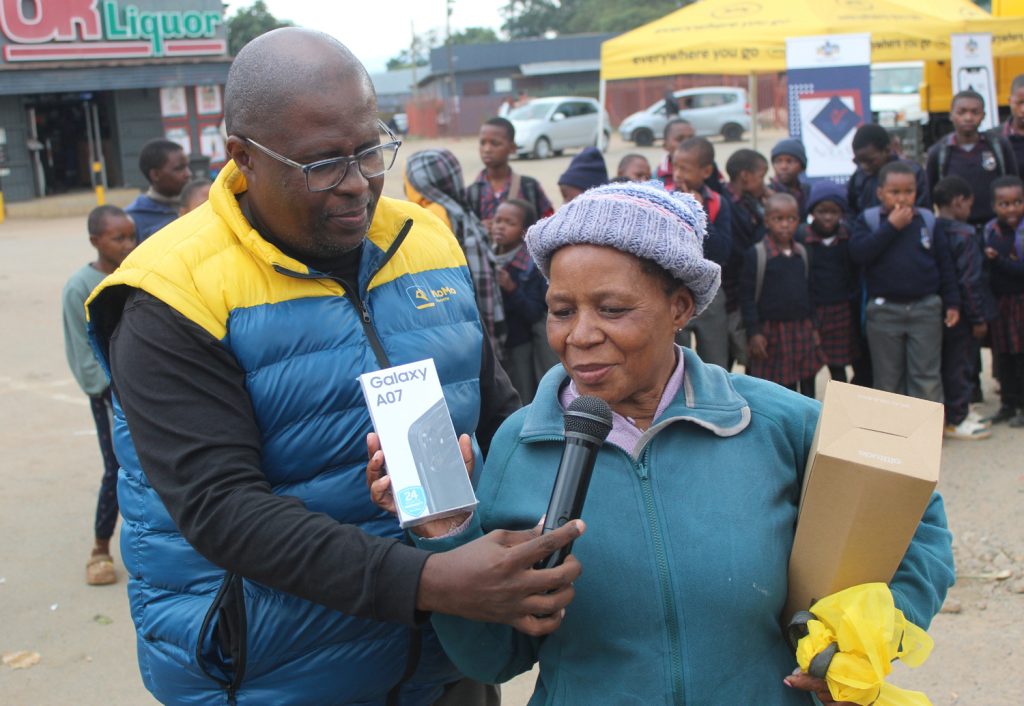 Winner of the 'Grab the Phone' challenge Nomvuyo Matsebula displays a Galaxy A07 while Nhlanhla Dlamini interviews her.