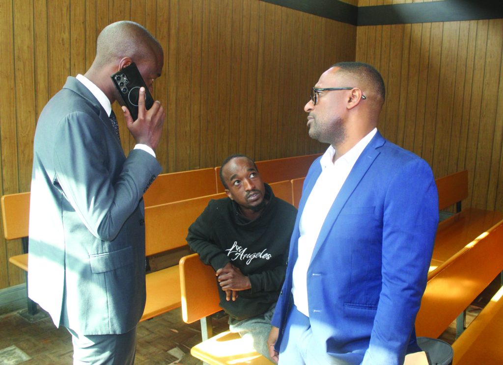 Vuyo Mbatsana in consultation with his lawyer Sivesonkhe Ngwenya and investigating officer Bheki Dlamini before the start of the court proceedings.