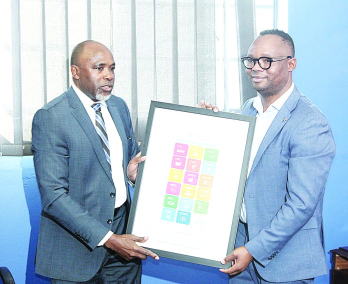 Acting Eswatini Observer MD Mbongeni Mbingo accepts a gift from the UN Resident Coordinator George Wachira during his visit to the Eswatini Observer offices yesterday.
