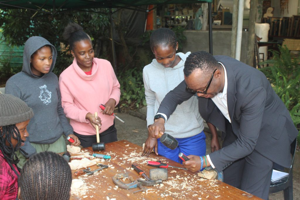 Eswatini Observer Acting Managing Director Mbongeni Mbingo tries his hand on some of the artwork.